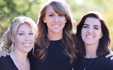 Three women smiling together at a dental practice in Woodbury, MN.