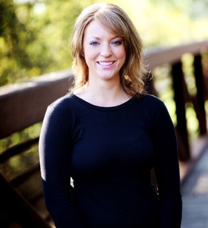 Professional headshot of a woman smiling outdoors at a dental practice in Woodbury, MN.