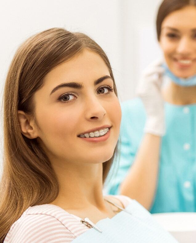 Smiling patient with dental braces displaying results of orthodontic treatment.