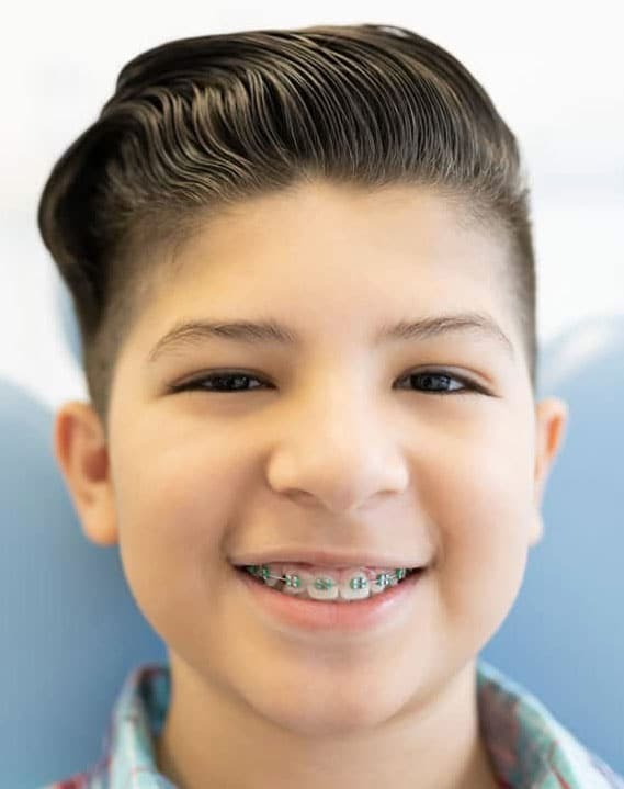 Young patient with metal braces smiling at dental office in Woodbury, MN.