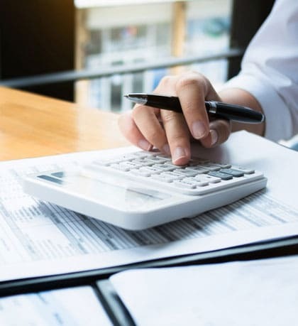 Dentist reviewing dental financing options and payment plans using calculator and documents.