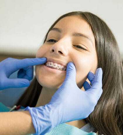 Orthodontist examining patient's braces during dental treatment in Woodbury, MN.