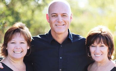 Three smiling dental professionals posing together at Woodbury, MN practice.