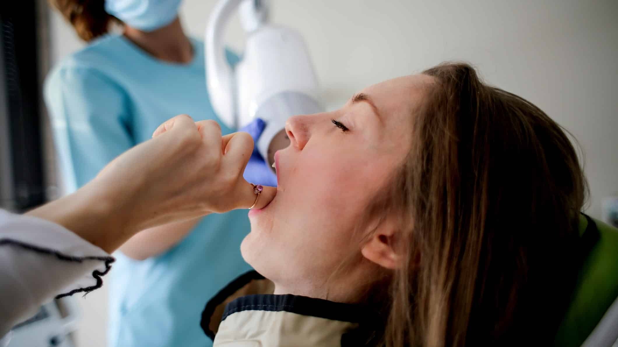 Young patient using an inhaler during orthodontic treatment appointment.