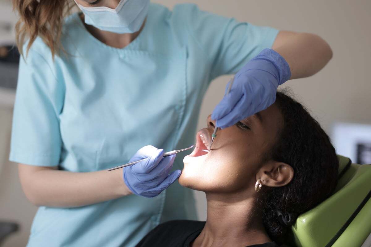 Dentist examining patient's teeth during Invisalign treatment consultation.