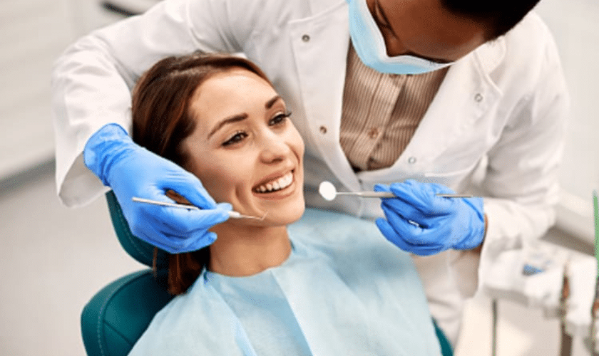 Smiling patient receiving dental examination from orthodontist in Woodbury.