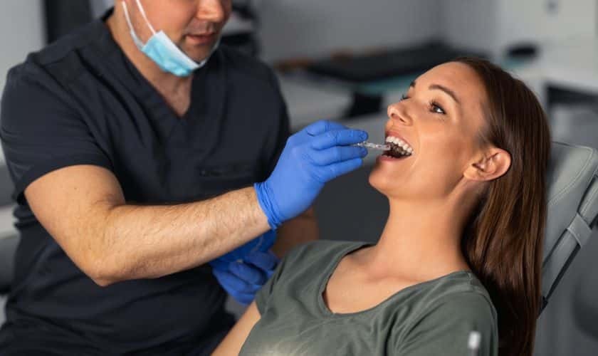 Dentist examining patient's teeth during oral examination in dental office.