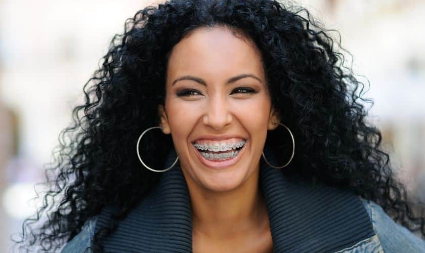 Happy patient with braces smiling at dental practice in Woodbury, MN.
