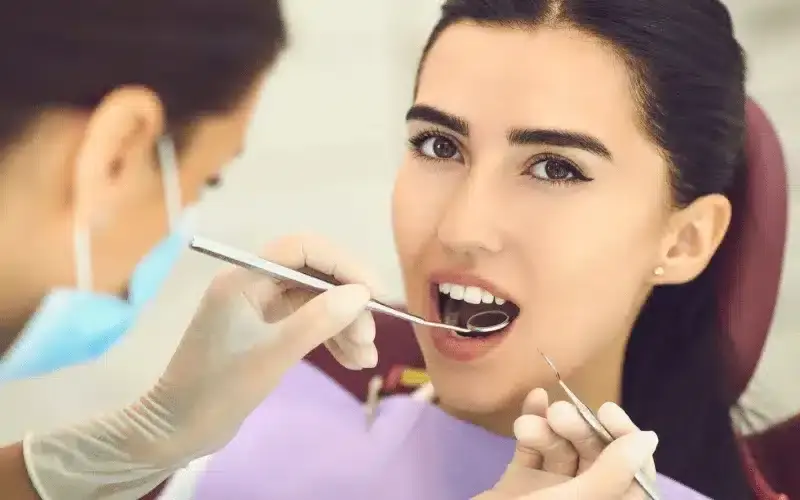 Dentist examining patient's teeth during orthodontic consultation in Woodbury.
