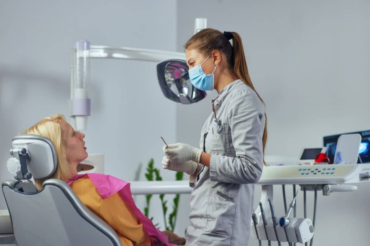 Dental hygienist examining patient in modern Roseville orthodontic office with intraoral camera.