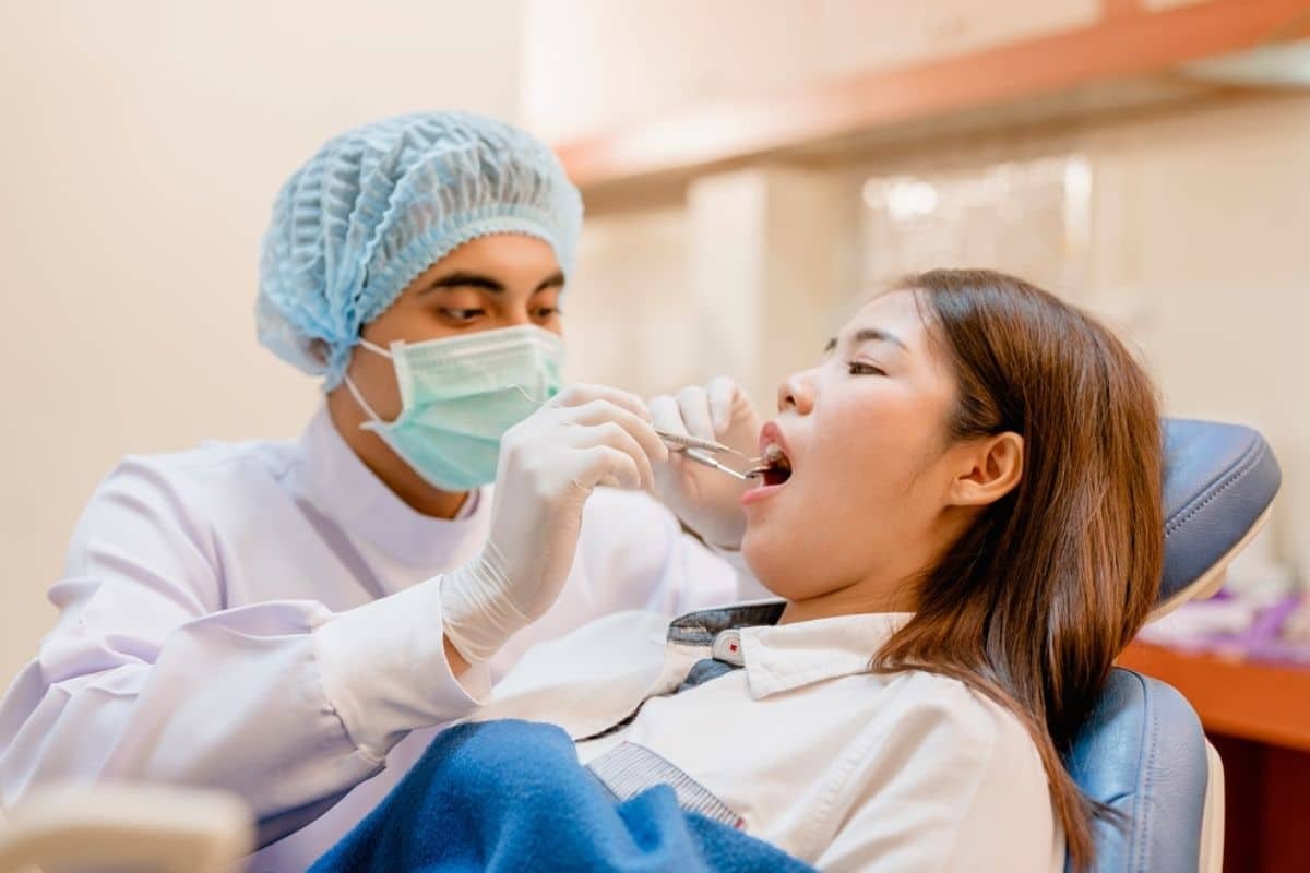Dentist examining patient's mouth during orthodontic consultation at dental office.