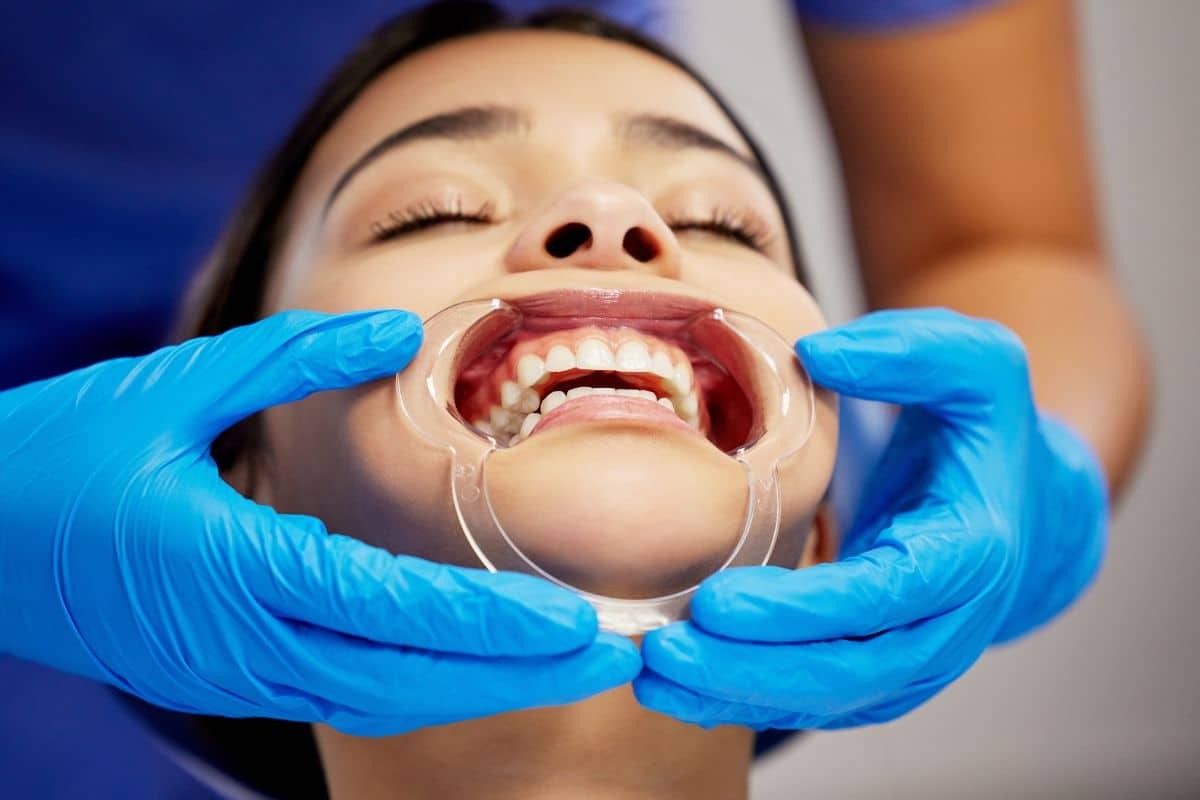 Dentist examining patient's teeth during orthodontic evaluation in Woodbury.